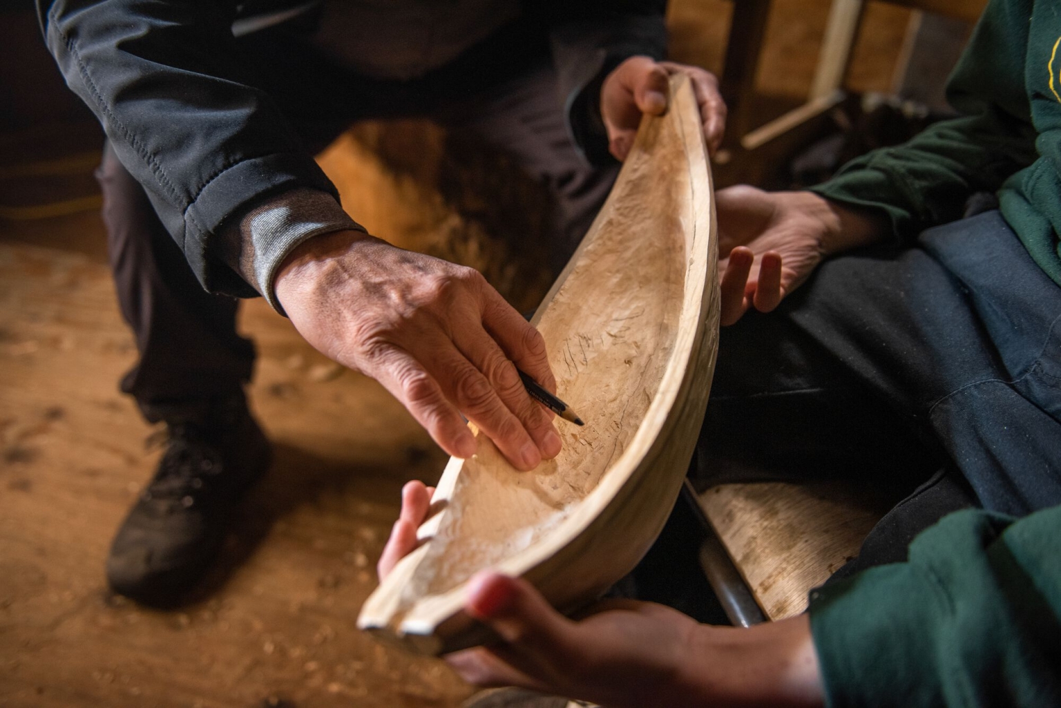 Master carver Calvin McNeil holds up one of his works to demonstrate the carving process.